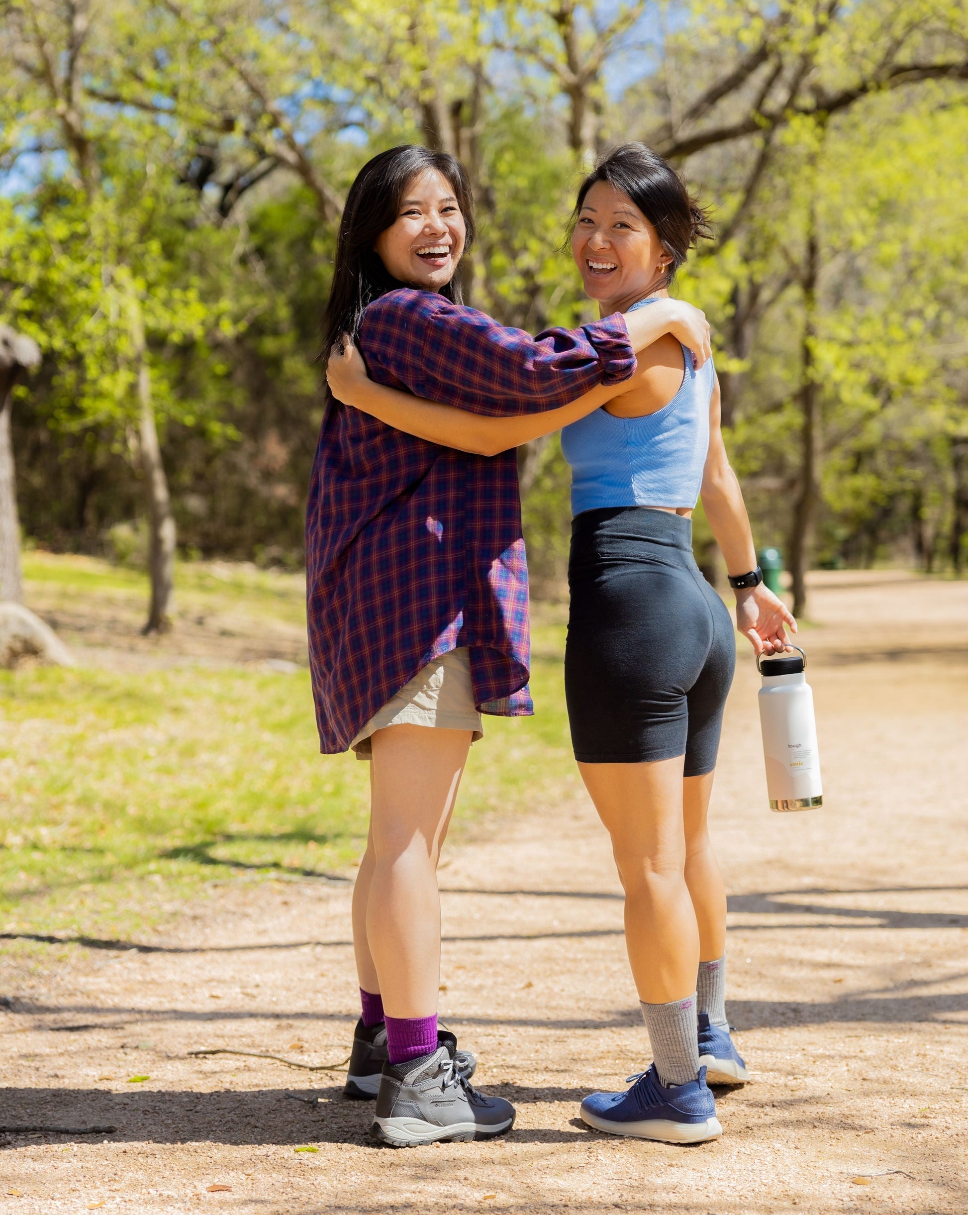 Two asian women, one chinese, one korean walk together in nature wearing ToughCutie socks